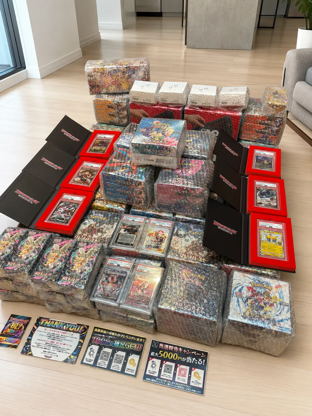 床一面に並んだ緩衝材入りのポケモンカードBOXとPSA鑑定品